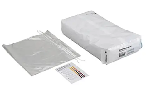 Wartungsset von Grünbeck mit einem weißen, verpackten Element und einem transparenten Beutel, daneben eine farbige Skala zur Analyse oder Messung.